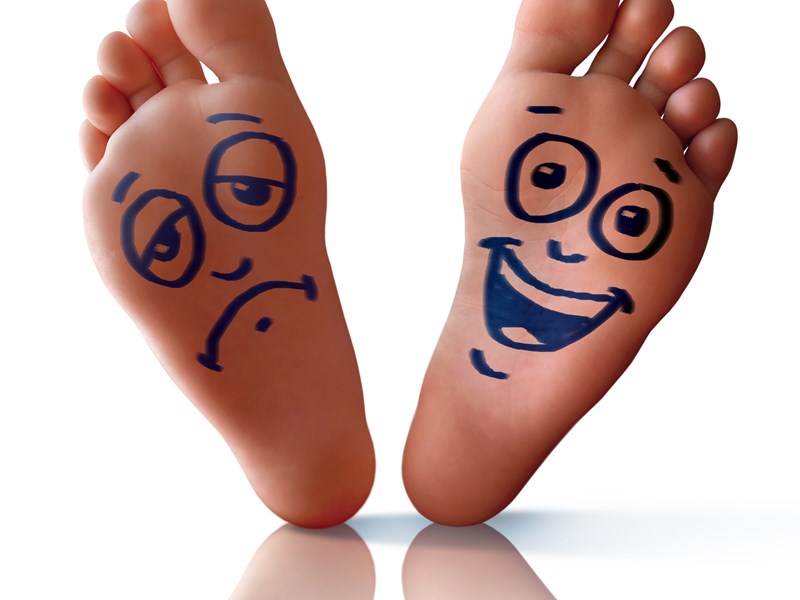 Soles of feet with a happy and sad face drawn on